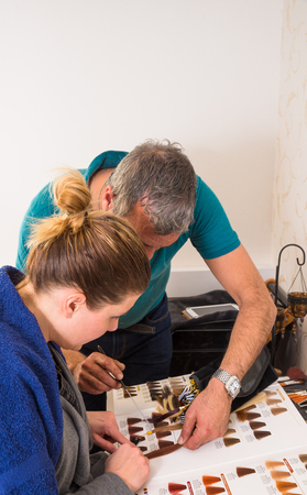 Haidresser helping client to choose her new hair colorの写真素材