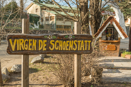 VILLA GENERAL BELGRANO, ARGENTINA - AUGUST 25 2015: Sign and small chapel reminding the German origin of its settlersのeditorial素材