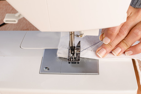 Female hands working with a sewing machinge
