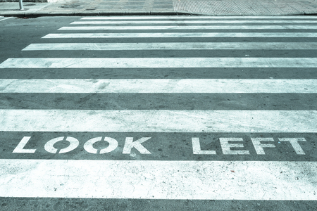 Pedestrian crossing with warning for tourists used to traffic coming from the opposite directionの写真素材