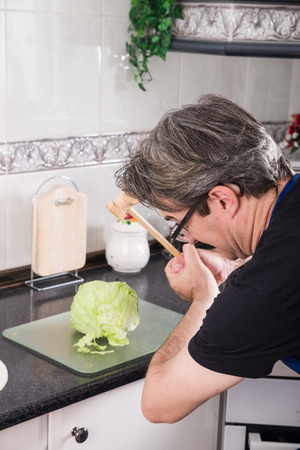 Guy wanting to use a meat tenderizer to chop lettuceの写真素材