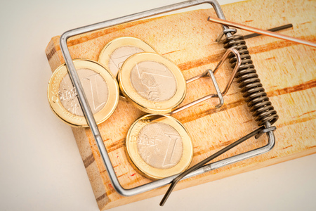 Euro coins on a mouse trap, a concept representing the currrent troubles of the European currencyの写真素材