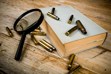 Detective novel concept  with book, bullets and magnyfying glassの写真素材