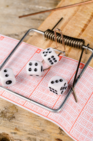 Dice and lottery ticket in a mousetrap, a conceptの写真素材