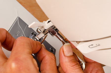 Female hands doing maintenance work on a domestic sewing machine