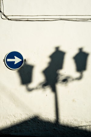 Traffic sign on a whitewashed wall with the shade of  lagre street lightsの写真素材