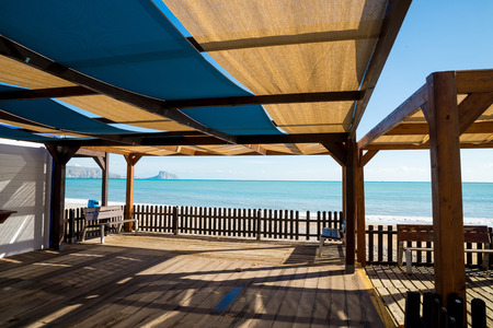 Shaded wooden terrace on a sunny Mediterranean beachの写真素材