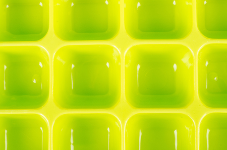 Studio shot of a green plastic ice cube trayの写真素材