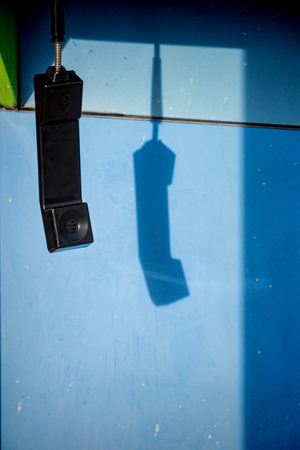 Dangling handset of a phone booth, a loneliness conceptの写真素材