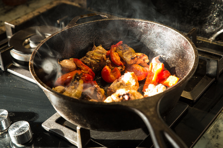 Cooking garlic chicken in  a cast iron potの写真素材