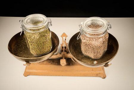 Jars with legumes on  vintage scales, a healthy eating conceptの写真素材