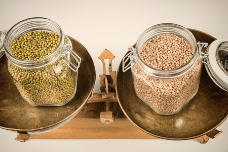 Jars with legumes on  vintage scales, a healthy eating conceptの写真素材