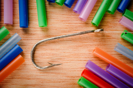 Fishing hook surrounded by drinking straws, a concept of the pollution of the oceans with plastic...