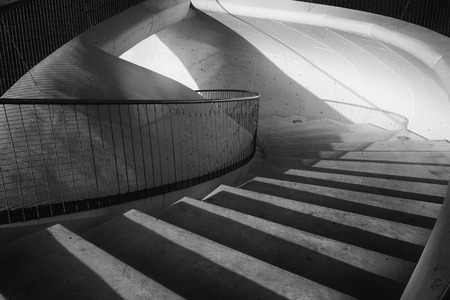 Curved staircase with reflections of sunlight coming inの写真素材