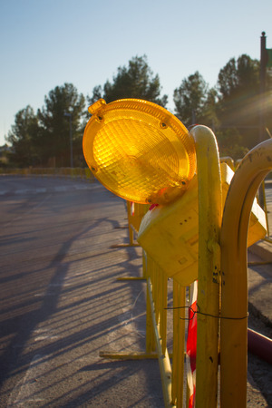 Roadworks warning light amidst other construction equipmentの写真素材