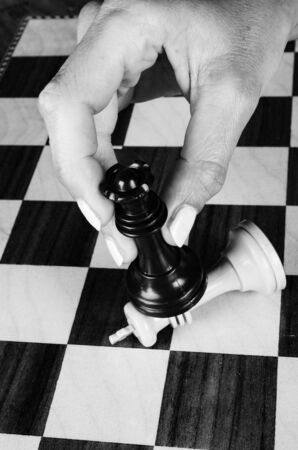 Female hand carrying a chess queen against the king, a conceptの写真素材