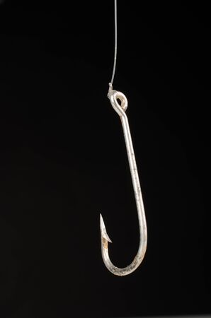Fishing hook on black background, a concept