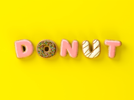 Delicious donuts with shape of letters glaze on yellow background 3 D illustrationの写真素材