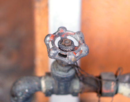 Old water valve used to control the flow of water. Is situated in front of the house.の写真素材