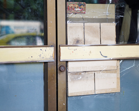 The old glass doors of the paint shop. The cracks from being vandalized by thieves.の写真素材