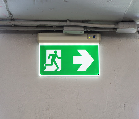 Green emergency exit sign in the parking of the department store.の写真素材