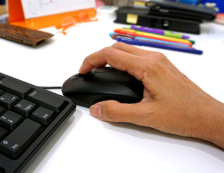 Closeup of business woman hand on the  mouse  of  computer PC.