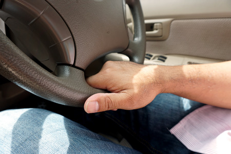 Man's hand on wheel car driving on the road  in the afternoon.の写真素材