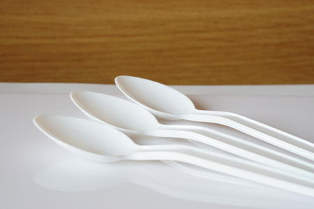 White three empty long plastic spoons  on the table                             の写真素材