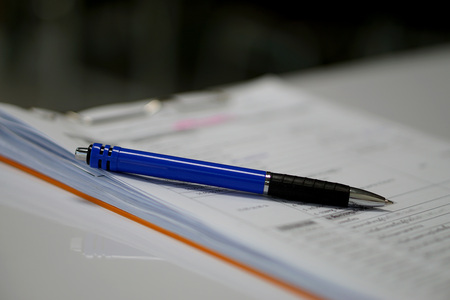 Blue pen on document white paper. office supply and business concept
