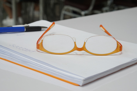Orange glasses  on document white paper. Office supply and business concept.の写真素材