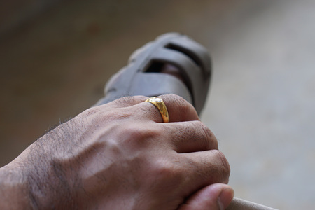 Closeup Hand of a man wearing a wedding ring  and placed hand on his leg.               の写真素材