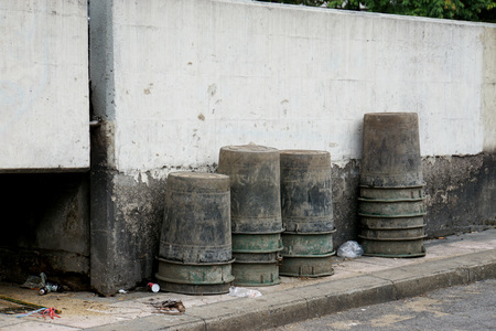Stack of old black plastic container use to keep gabage place beside street.                        ...