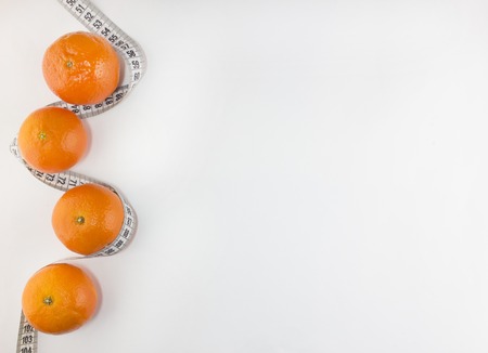 Mandarins and centimeter on a white backgroundの写真素材
