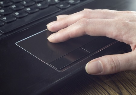 Hand on the laptop's touchpad, technology, close upの写真素材