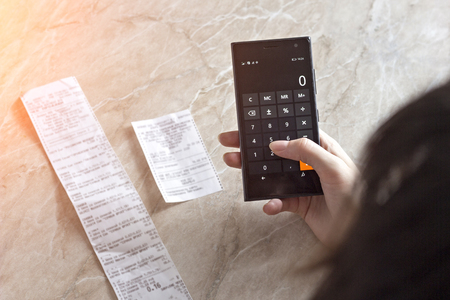 The girl counts the costs of checks on the phone, close-upsの写真素材