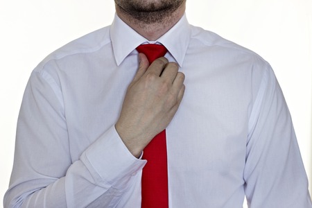 Bearded man in a white shirt with a red tie on a white background, close-upの写真素材