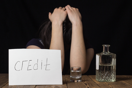 Girl with alcohol on a black background and lettering creditの写真素材