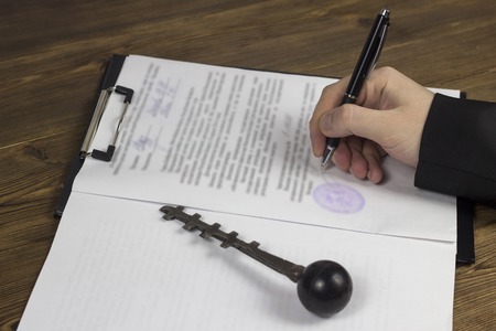 Buying a garage, garage key, pen, contract, handの写真素材