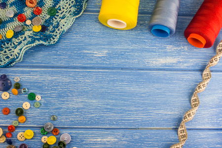 Threads and buttons, centimeter tape on a blue wooden backgroundの写真素材