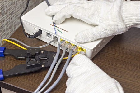 A man connects a network cable to the modem, a close-upの写真素材