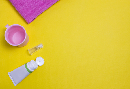 Toothpaste and brush for the youngest children, yellow backgroundの写真素材