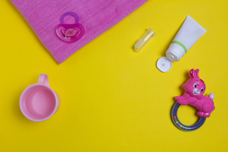 Children's toothpaste and brush on a yellow background, children's toys and nipples, for children under 2 yearsの写真素材