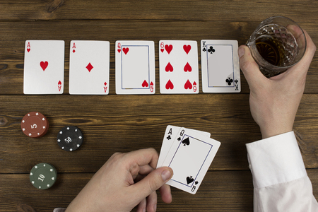Poker chips card alcohol hand, wooden background, a glass and a white shirt, stackの写真素材