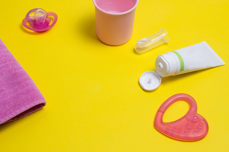 Baby toothbrush accessories for baby, toothpaste and brush on a yellow background for the little ones, nippleの写真素材
