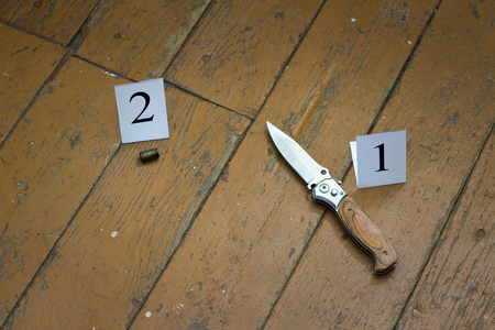 Knife and cartridge case on a brown wooden background, murder, robbery, evidence on the floor, investigation, abuseの写真素材