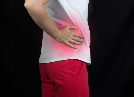 The girl holds on to her side, which has a kidney, sand and kidney stones, pilonephritisの写真素材