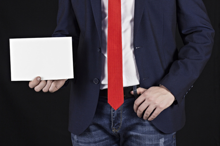 Businessman in a jacket holding a blank sheet in his hand, notepadの写真素材