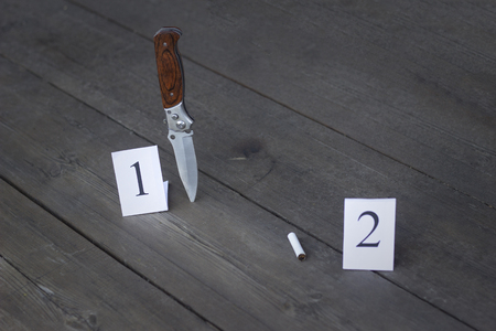 Stub and folding knife on a wooden background, evidence and investigation, close-up, two cluesの写真素材