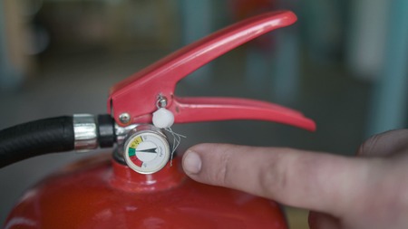 forefinger shows what pressure should be in the fire extinguisher, class A and B, close up, arm indicates a pressure sensor, fire safety briefingの写真素材