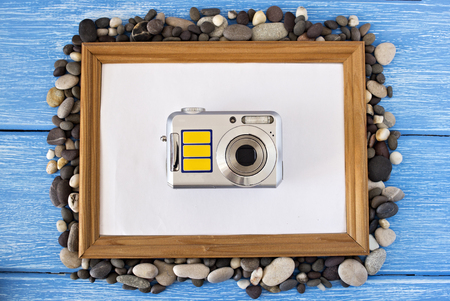 Clean frame on a blue wooden background, seashells and cameraの写真素材